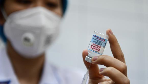 A health worker prepares to administer the Moderna Covid-19 coronavirus vaccine to local residents at a primary school in Hanoi on July 27, 2021. (Photo by NHAC NGUYEN / AFP)