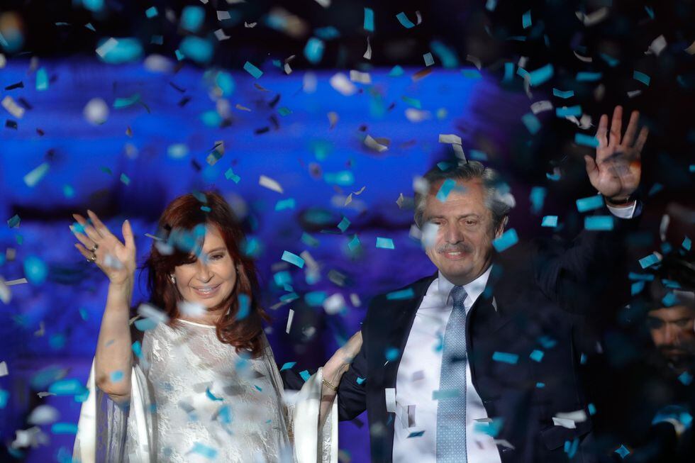 El Presidente Alberto Fernández (izq.) y la Vicepresidenta Cristina Kirchner (der.) saludan a sus simpatizantes durante celebración en la Casa Rosada. (Foto: EFE)