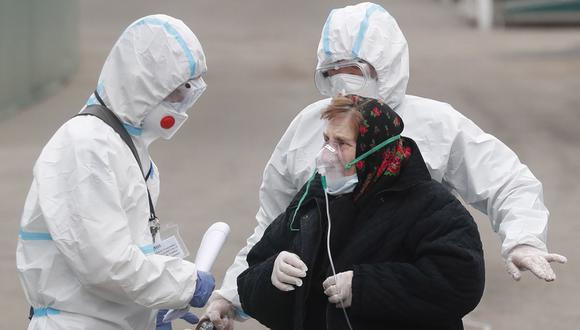 Una paciente de coronavirus siendo escoltada por trabajadores de la salud en Moscú. (Foto: EFE)