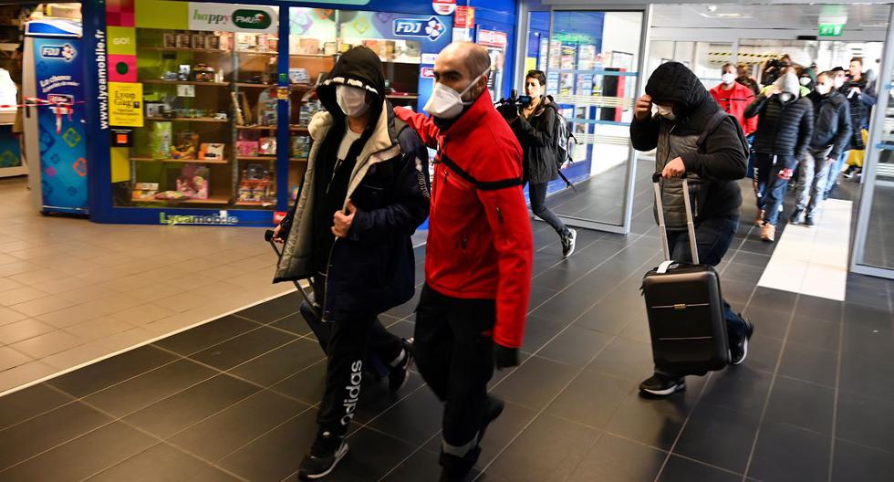 Un grupo de personas usan mascarillas protectoras son evacuadas de una estación de trenes y autobuses en Lyon debido a la sospecha de COVID-19. (AFP)