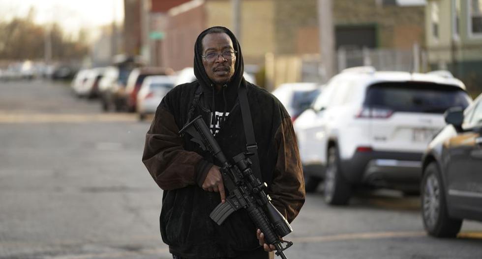 Erick Jordan camina por la calle con su fusil para ofrecer protección, el viernes 19 de noviembre de 2021, en Kenosha, Wisconsin. (AP Foto/Paul Sancya).