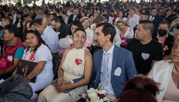 Una pareja se toma de la mano durante una boda colectiva el día de San Valentín en la explanada del Palacio Municipal de Nezahualcóyotl en Nezahualcóyotl, México, el 14 de febrero de 2023. (Foto de NICOLAS ASFOURI / AFP)