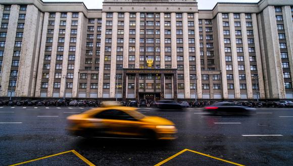 Los autos pasan frente al edificio de la Duma Estatal, la cámara baja del parlamento de Rusia, donde los legisladores considerarán tratados para anexar formalmente cuatro regiones de Ucrania que ocupan las tropas rusas: Lugansk, Donetsk, Kherson y Zaporizhzhia, en Moscú el 3 de octubre de 2022. (Foto por Yuri KADOBNOV / AFP)