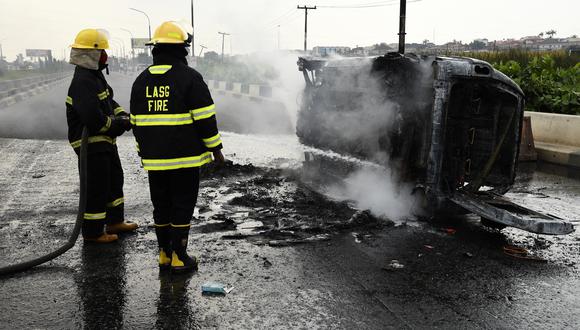 Los bomberos intentan apagar un automóvil atascado en medio de la carretera que provocó un embotellamiento de tráfico en el distrito de Alapere de Lagos, el 15 de enero de 2021. (Foto referencial: PIUS UTOMI EKPEI / AFP)