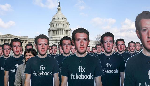 Avaaz.org Campaign Director Nell Greenberg, (L), walks among dozens of cardboard cut-outs of Facebook CEO Mark Zuckerberg while holding a protest outside of the U.S. Capitol building in Washington, U.S., April 10, 2018. REUTERS/Leah Millis