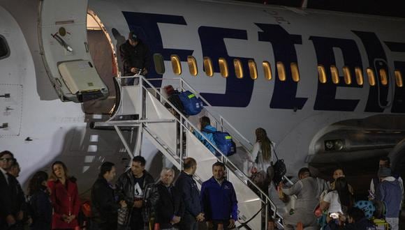 Migrantes abordan un avión de la aerolínea Estelar con destino a Venezuela, en el aeropuerto Internacional Chacalluta de Arica, Chile, el 7 de mayo de 2023. (Foto de Lucas Aguayo Araos / EFE)