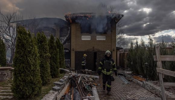 Bomberos en acción mientras el fuego y el humo salen de una casa después de los bombardeos de Rusia en Kharkiv. (EFE/EPA/ROMAN PILIPEY)