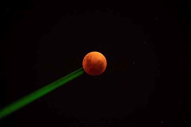 Krwawy księżyc jest widoczny podczas całkowitego zaćmienia Księżyca w Santiago, 15 maja 2022 r. (MARTIN BERNETTI / AFP).