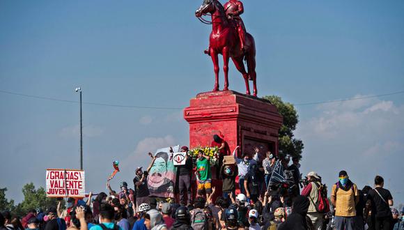 La estatua de Manuel Baquedano pintada de rojo durante una marcha realizada en octubre del 2020 en Santiago de Chile. El laureado militar chileno es señalado como genocida de comunidades mapuches, por lo que los manifestantes exigen que su imagen sea retirada de la plaza rebautizada como de la Dignidad. (Foto: Martin Bernetti / AFP)