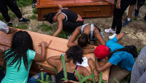Familiares y amigos lloran en el entierro de Johander Perez y Wuilkerman Ruiz en el Cementerio General de Caracas. Ambos fueron supuestamente asesinados por las FAES. (AFP).