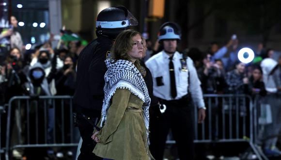 La policía de Nueva York arresta a una estudiante mientras desaloja un edificio que había sido tomado en la Universidad de Columbia. (Foto de CHARLY TRIBALLEAU / AFP).