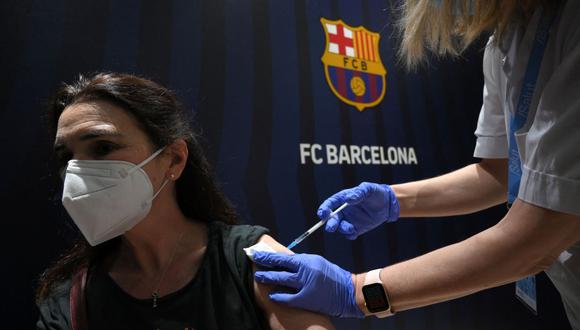 Una mujer recibe un pinchazo de la vacuna Pfizer-BioNTech durante una campaña de vacunación contra el COVID-19 en el estadio Camp Nou de Barcelona, el 27 de mayo de 2021. (Foto por LLUIS GENE / AFP).