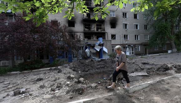 Una mujer pasa frente a un edificio residencial dañado por los bombardeos en la ciudad de Siversk, región de Donetsk, el 23 de junio de 2022. (ANATOLII STEPANOV / AFP).