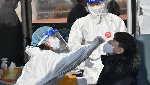 Personal sanitario toma una muestra nasal para detectar el coronavirus covid-19 en un centro de pruebas en Seúl el 9 de febrero de 2022. (Jung Yeon-je / AFP).