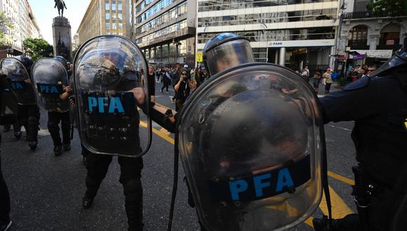 Miembros de la Policía Federal de Argentina hacen guardia mientras los manifestantes marchan hacia la Plaza de Mayo durante la primera manifestación contra el nuevo gobierno de Javier Milei, el 20 de diciembre de 2023. (Foto de Luis ROBAYO/AFP).
