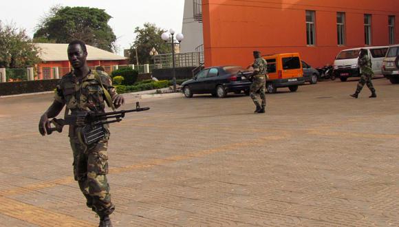 En esta foto de archivo tomada el 14 de abril de 2012, los soldados caminan afuera de la Asamblea Nacional en Guinea Bissau. El martes se escucharon disparos sostenidos cerca de la sede del gobierno. (ALFA BALDE / AFP).