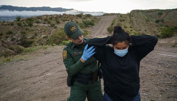 La agente de la Patrulla Fronteriza de Estados Unidos Valeria Morales registra a una mujer ecuatoriana que fue atrapada tratando de ingresar al país desde México. (PAUL RATJE / AFP).