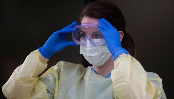 Una trabajadora de la salud del Centro Hospitalario de Virginia, en Estados Unidos, se pone su equipo de protección  contra el coronavirus. (AFP / ANDREW CABALLERO-REYNOLDS).