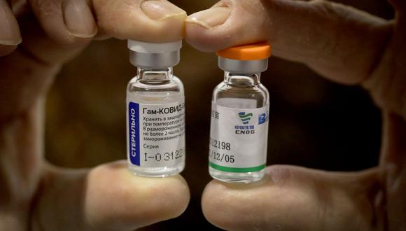 Un trabajador sanitario serbio muestra viales de vacunas contra el coronavirus Sputnik V de Rusia y Sinopharm de China en Belgrado. (Foto de OLIVER BUNIC / AFP).