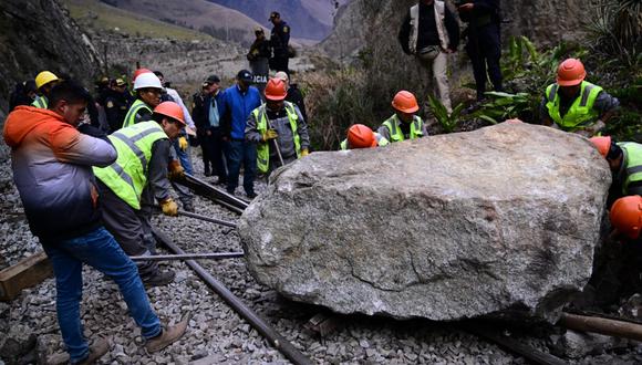 Trabajadores intentan mover las enormes rocas con las que los manifestantes bloquearon las vías del tren que conecta a Ollantaytambo con la ciudad de Machu Picchu, en Cusco.