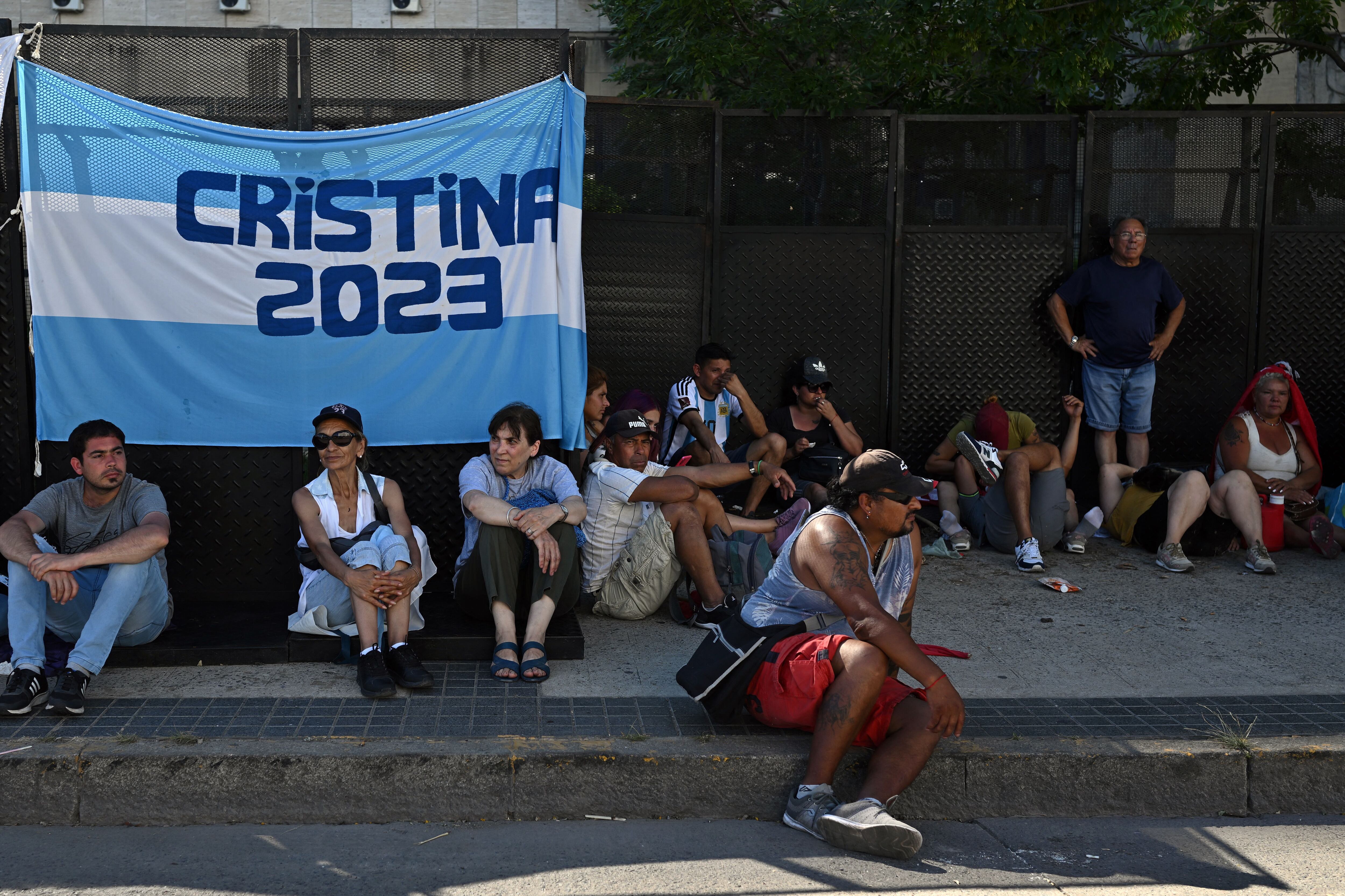 Supporters of Argentina's Vice President Cristina Fernández de Kirchner wait outside the Comodoro Py Palace of Justice in Buenos Aires on December 6, 2022. (Photo by Luis ROBAYO / AFP)