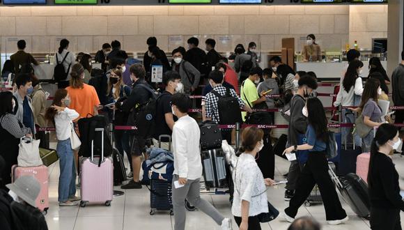 Los viajeros esperan en fila frente a los mostradores de facturación en el aeropuerto de Gimpo en Seúl, Corea del Sur, el 29 de setiembre de 2020. (Jung Yeon-je / AFP).
