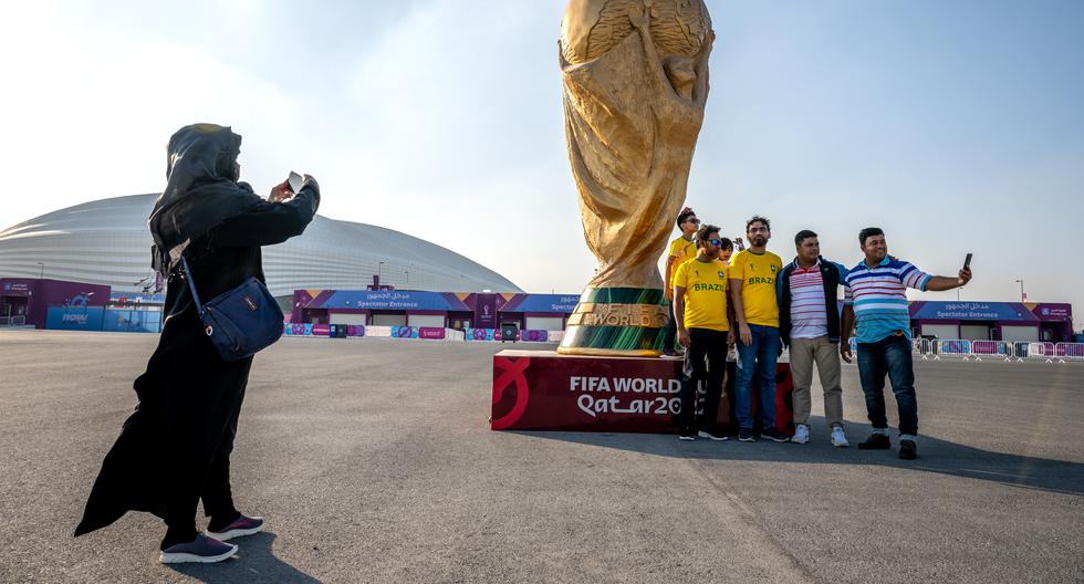 Una réplica gigante de la copa del mundo es el lugar preferido para los ‘selfies’. Aquí, fanáticos de Bangladesh, vestidos con camisetas de Brasil, inmortalizan su visita. Atrás, el estadio Al-janoub, al sur de Doha. (Foto: AFP)