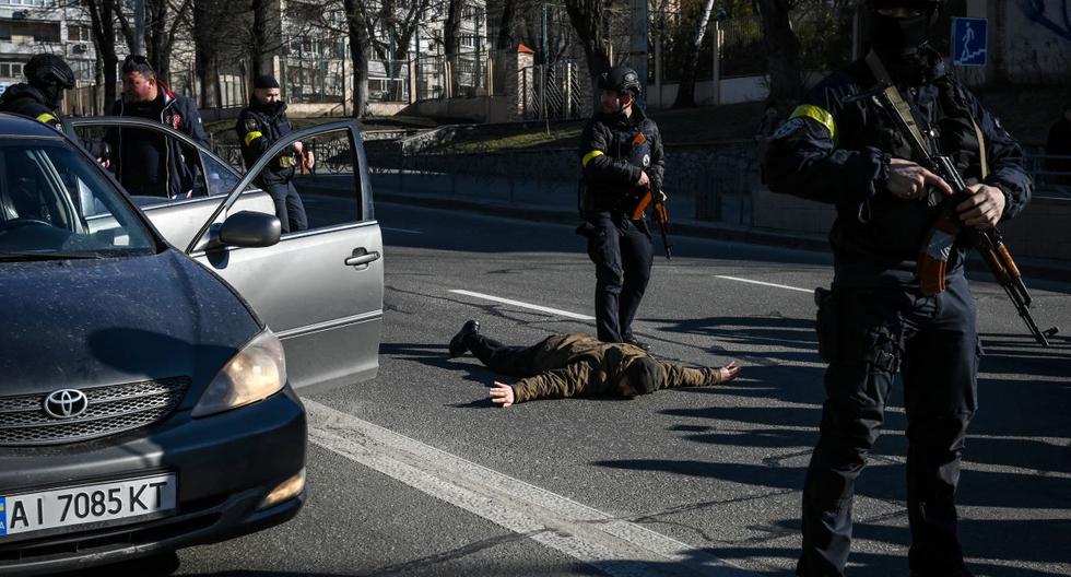 Policías de Ucrania detienen autos para controlar a las personas mientras buscan a hombres sospechosos en una calle de Kiev, el 27 de febrero de 2022. (ARIS MESINIS / AFP).