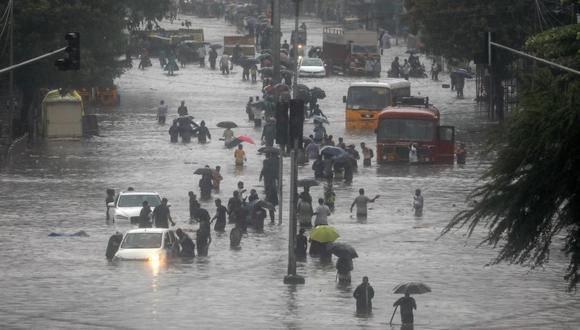 Las personas caminan por una calle inundada por las fuertes lluvias en Bombay, India, el 9 de junio de 2021. (EFE / EPA / DIVYAKANT SOLANKI).
