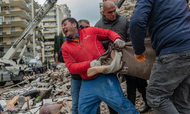 Un rescatista reacciona mientras lleva un cuerpo encontrado entre los escombros en Adana, Turquía, el 6 de febrero de 2023, después de que un terremoto de magnitud 7,8 azotara el sureste del país.(Foto de Can EROK / AFP).