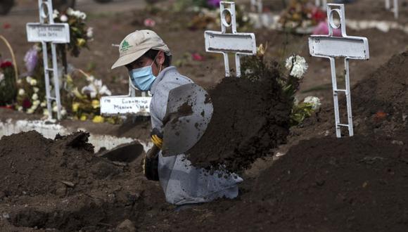 El sepulturero Fernando Quezada, de 27 años, usa una pala mientras trabaja en el Cementerio General de Santiago, el 5 de agosto de 2020, en medio de la pandemia del nuevo coronavirus COVID-19. (Foto: Claudio REYES / AFP).