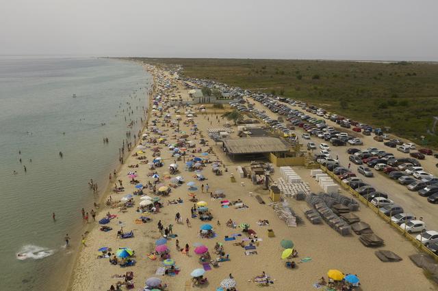 Imagen captada por un dron que muestra a las personas disfrutando de un día soleado en una playa cerca del pueblo de Epanomi, Salónica, Grecia. Cientos de playas abrieron al público tras haber estado cerradas debido a la pandemia de coronavirus. (EFE / EPA / DIMITRIS TOSIDIS).