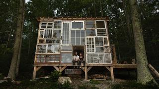 Una encantadora cabaña construida con ventanas reutilizadas