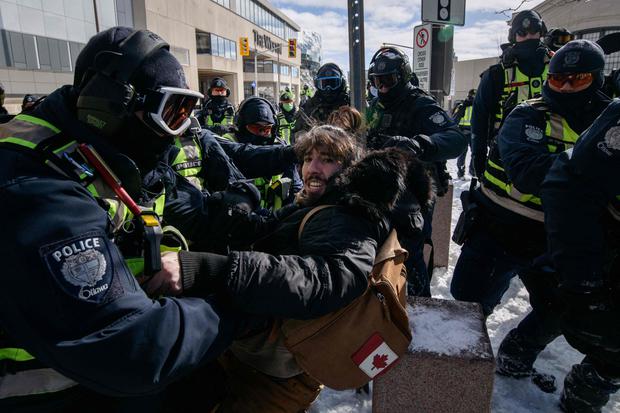 A protester (c) clashes with police during a trucker-led protest against epidemic health rules and the Trudeau government outside parliament in Ottawa, Canada.  (Photo: Ed Jones / AFP)