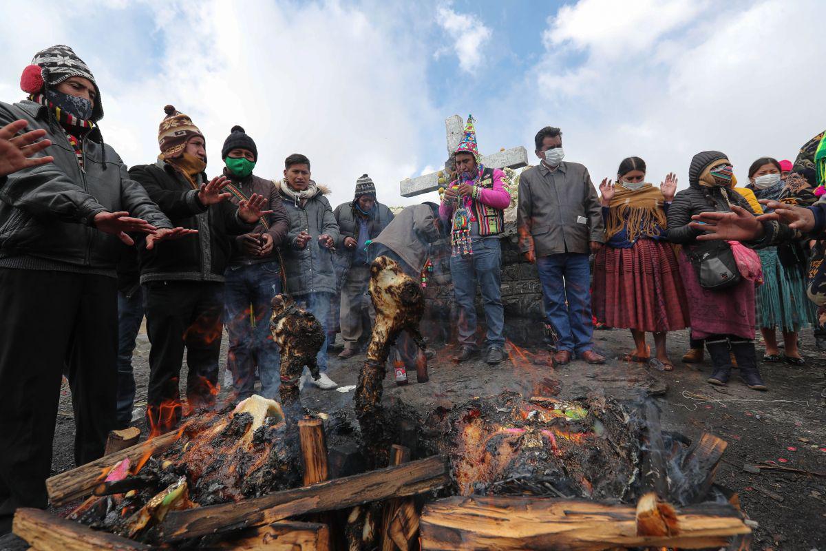 Sacerdotes e indígenas aimaras celebran un rito andino de "k'oa" en la apacheta de La Cumbre, en La Paz (Bolivia). (EFE/Martín Alipaz).