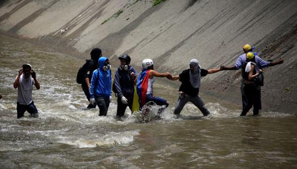 Manifestantes opositores saltaron al r&iacute;o Guaire para escapar de los gases lacrim&oacute;genos de la Guardia Nacional Bolivariana de Venezuela. (REUTERS/Marco Bello).