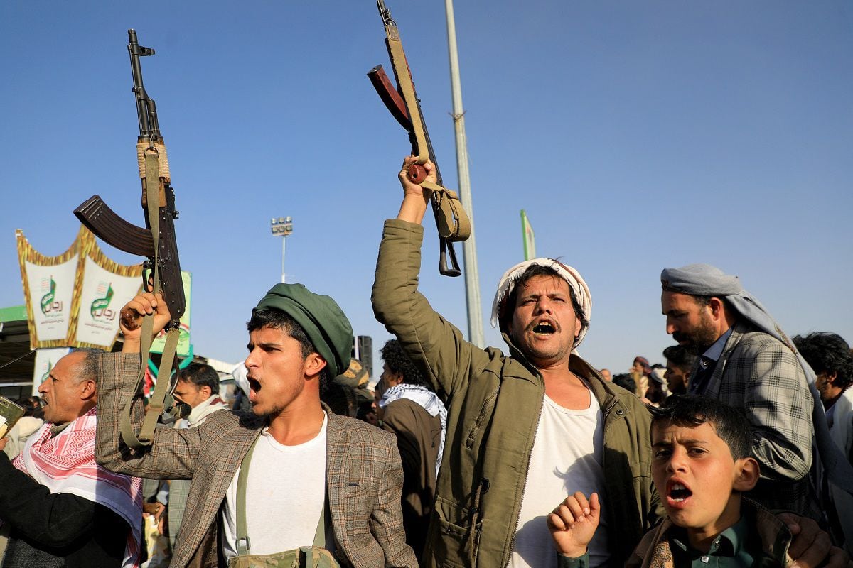 Houthi fighters brandish their weapons during a protest following attacks by American and British forces, in the Houthi-controlled capital Sana'a on January 12, 2024. (Photo by MOHAMMED HUWAIS/AFP)