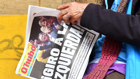 Una mujer sostiene un periódico local cuya primera página dice "¡Giro a la izquierda!" el día después de la victoria de Gustavo Petro en las elecciones en Colombia. (DANIEL MUÑOZ / AFP).