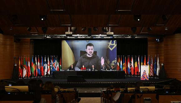 El presidente de Ucrania, Volodymyr Zelensky, se ve en una pantalla gigante mientras pronuncia un discurso durante la sesión anual de la Asamblea Parlamentaria de la OTAN celebrada en Madrid el 21 de noviembre de 2022. (Foto de OSCAR DEL POZO / AFP)