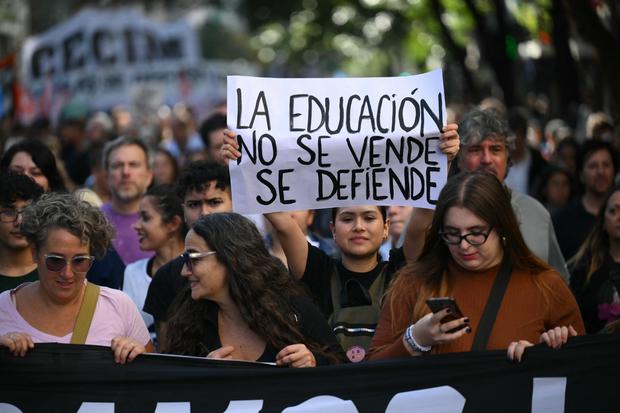 Una manifestante sostiene un cartel que dice "La educación no se vende, se defiende" durante una marcha en protesta por el ajuste presupuestario a las universidades públicas en Argentina. (Foto de Luis ROBAYO/AFP).