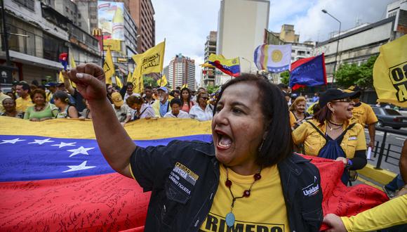 Una mujer del partido opositor "Primero Justicia" grita consignas durante una protesta por el retraso en el pago de algunas pensiones, en Caracas, el 25 de noviembre de 2016. (Foto de JUAN BARRETO / AFP)