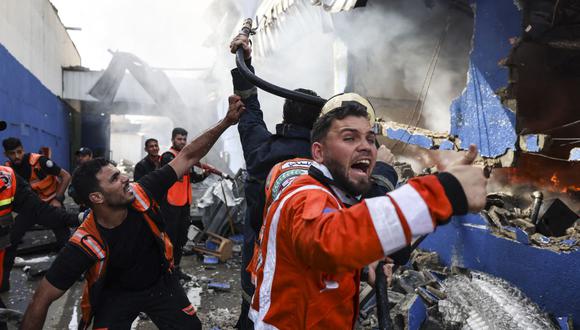 Los bomberos palestinos apagan un gran incendio en la fábrica de colchones Foamco al este de Jabalia en el norte de la Franja de Gaza, el 17 de mayo de 2021. (Foto de MAHMUD HAMS / AFP).