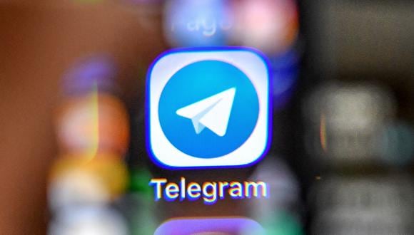 An illustration picture taken through a magnifying glass on April 17, 2018 in Moscow shows the icon of the popular messaging app Telegram on a smart phone screen. - Russia's communications watchdog began today blocking access to the popular messaging app Telegram after a court banned the service for refusing to give the security services access to private conversations. (Photo by Yuri KADOBNOV / AFP)