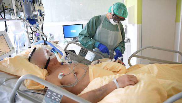Un trabajador de la salud que usa equipo de protección personal (EPP) trata a un paciente de coronavirus covid-19 en una unidad de cuidados intensivos del Hospital Universitario Tulln en Viena, Austria, el 27 de noviembre de 2020. (HELMUT FOHRINGER / APA / AFP).