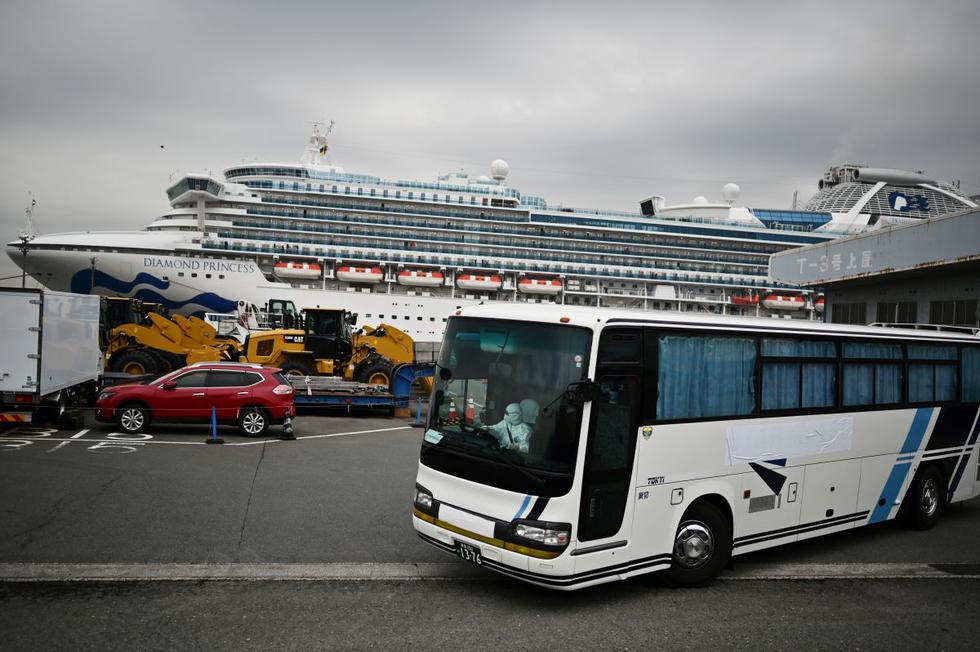 Un autobús con conductor con vestido con un equipo de protección sale del muelle junto al crucero Diamond Princess, que tiene a unas 3.600 personas en cuarentena a bordo. (AFP)