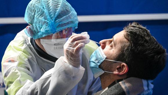Un trabajador de la salud toma un hisopo nasal a un hombre para realizar una prueba de coronavirus en un centro de pruebas en el centro de convenciones de Dunkerque (Francia), el 23 de febrero de 2021. (DENIS CHARLET / AFP).