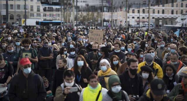 Un manifestante sostiene un cartel que dice "¿Quién nos protege de la policía?" Durante una manifestación en Marsella, sur de Francia. (AP / Daniel Cole)