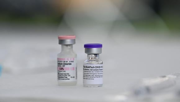 Vials of Pfizer Covid-19 vaccine and sodium cloride (used for dilution of the vaccine) are seen  at a community vaccination event in a predominately Latino  neighborhood in Los Angeles, California, August 11, 2021. - All teachers in California will have to be vaccinated against Covid-19 or submit to weekly virus tests, Governor Gavin Newsom  announced on August 11, as authorities grapple with exploding infection rates. The number of people testing positive for the disease has surged in recent weeks, with the highly infectious Delta variant blamed for the bulk of new cases. (Photo by Robyn Beck / AFP)