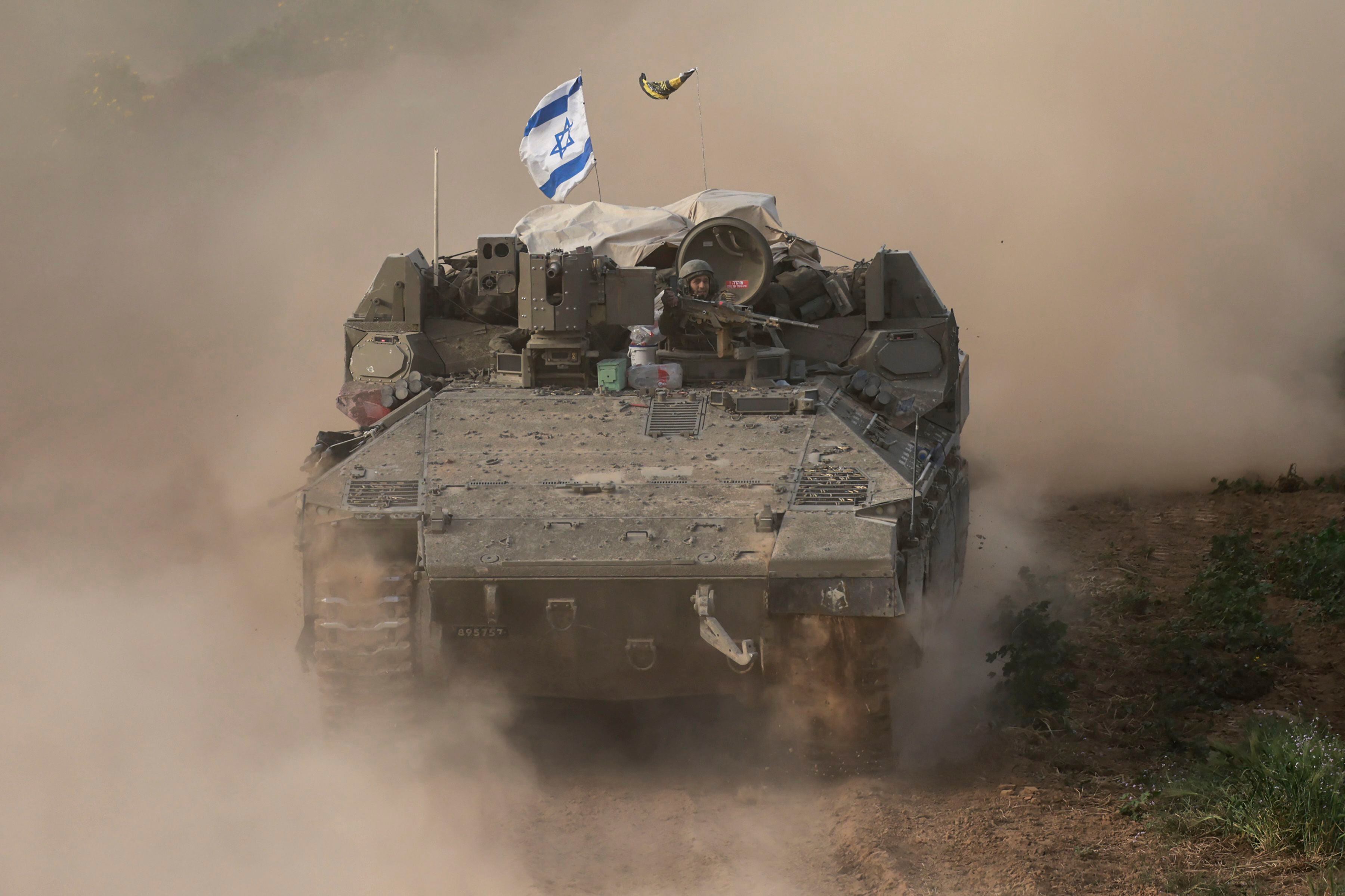 This photograph taken from Israel, near the border with the Gaza Strip, shows an Israeli soldier sitting in an armored vehicle on February 26, 2024. (Photo by Menahem KAHANA/AFP).