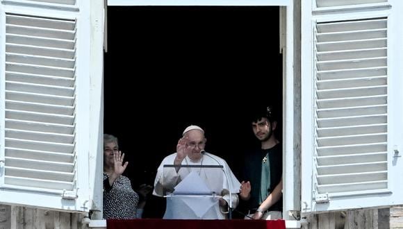 El papa Francisco, junto a una abuela y un nieto, aparece en la ventana del palacio apostólico con vista a la plaza de San Pedro durante la oración del Ángelus, en el Vaticano el 23 de julio de 2023. (Foto de Tiziana FABI / AFP)